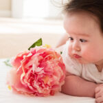 Happy baby boy with pink flower