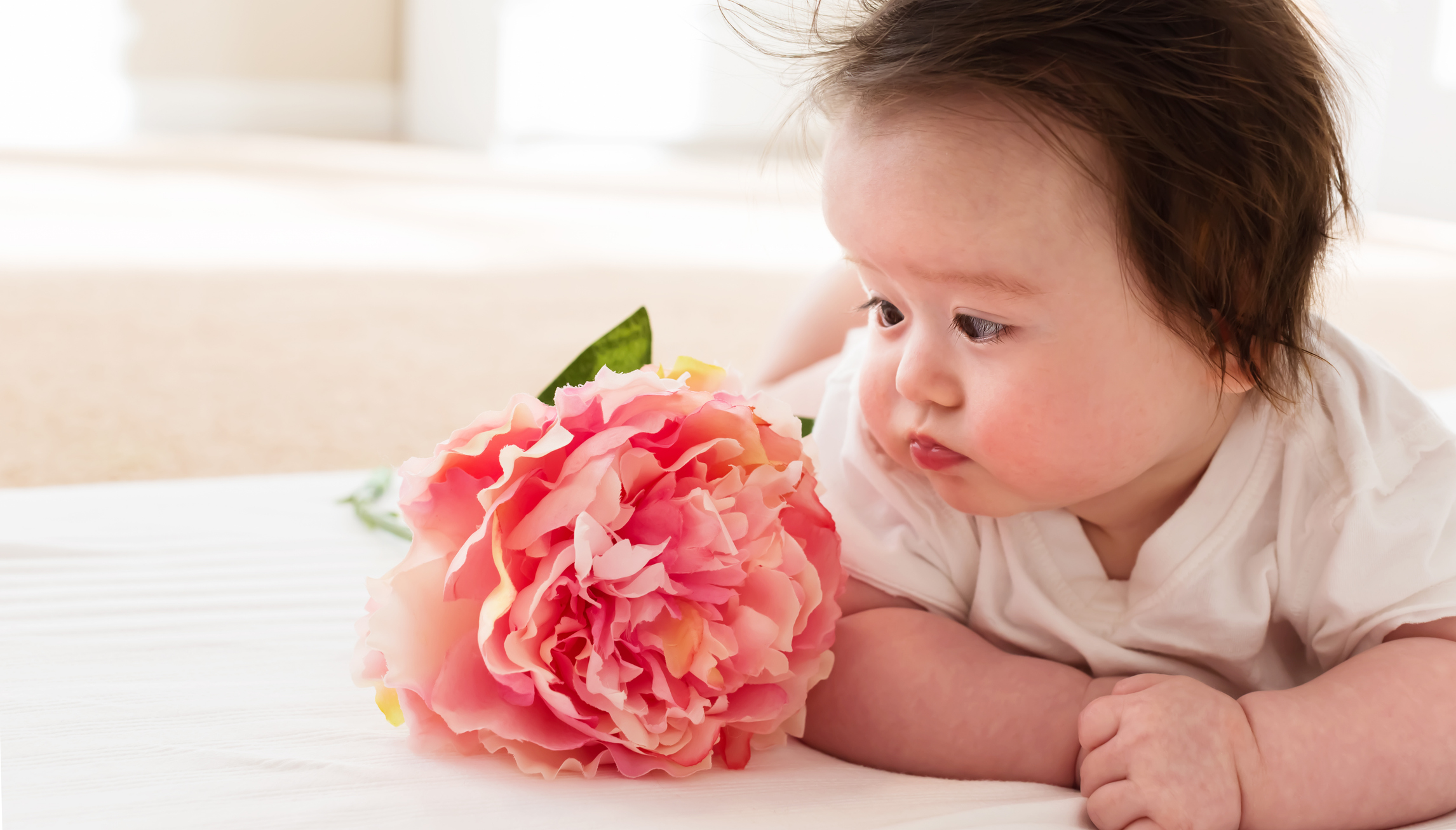 Happy baby boy with pink flower