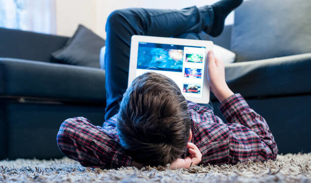 little boy lying with ipad