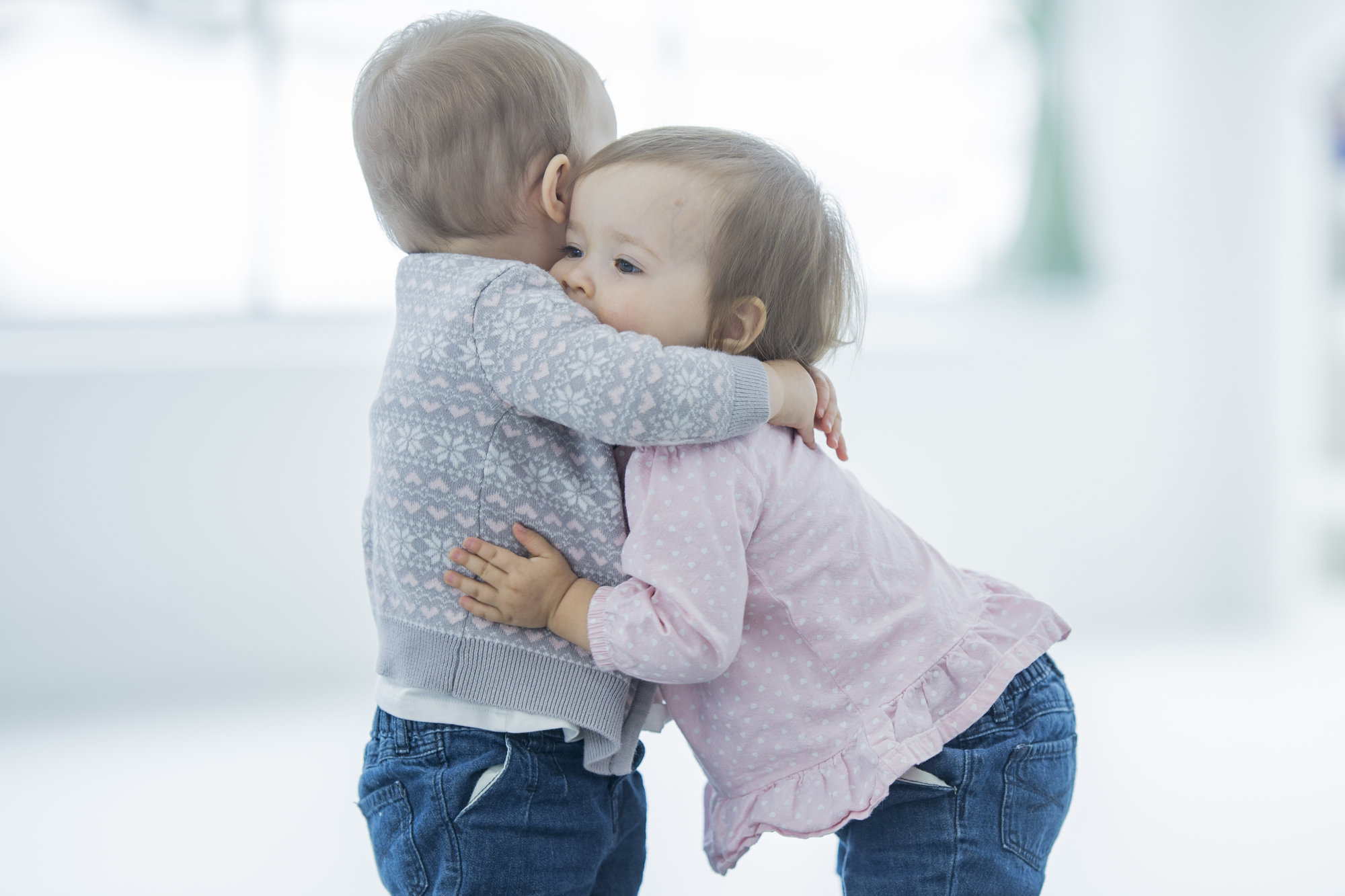 toddler boy and girl hugging