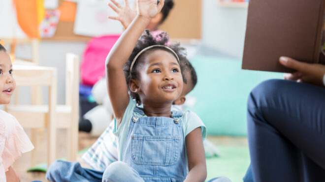 little girl raising her hand