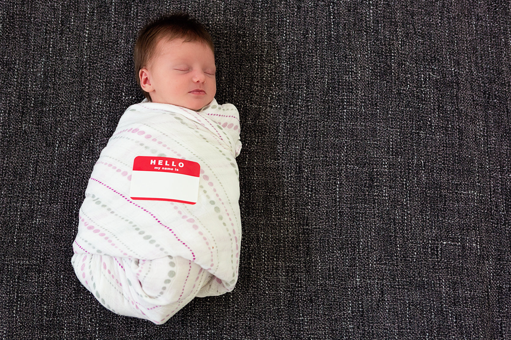 baby with hello my name is name tag