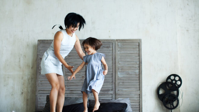 mom jumping on bed with kid