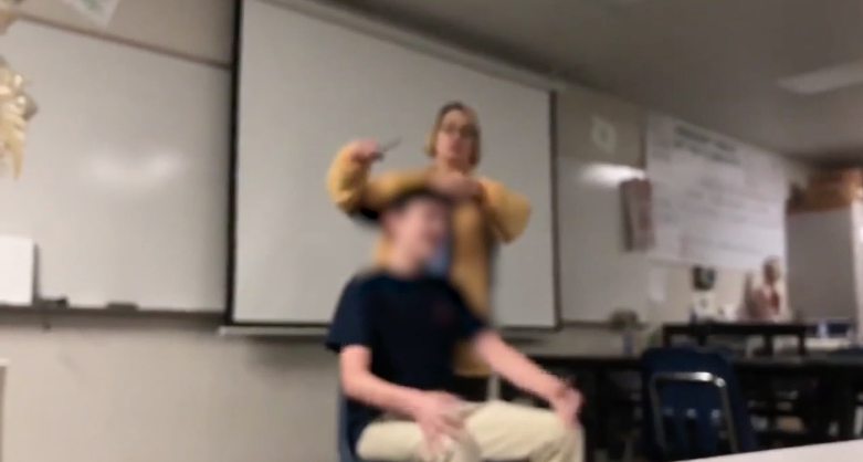 teacher cuts students hair