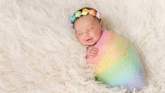newborn in rainbow flower crown and blanket