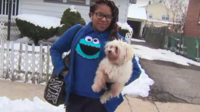 Teen Kayla Rose poses while smiling and holding up her small dog.