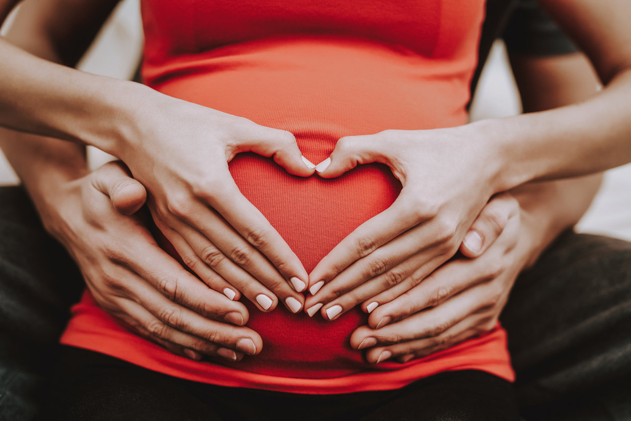 pregnant couple cradling baby bump