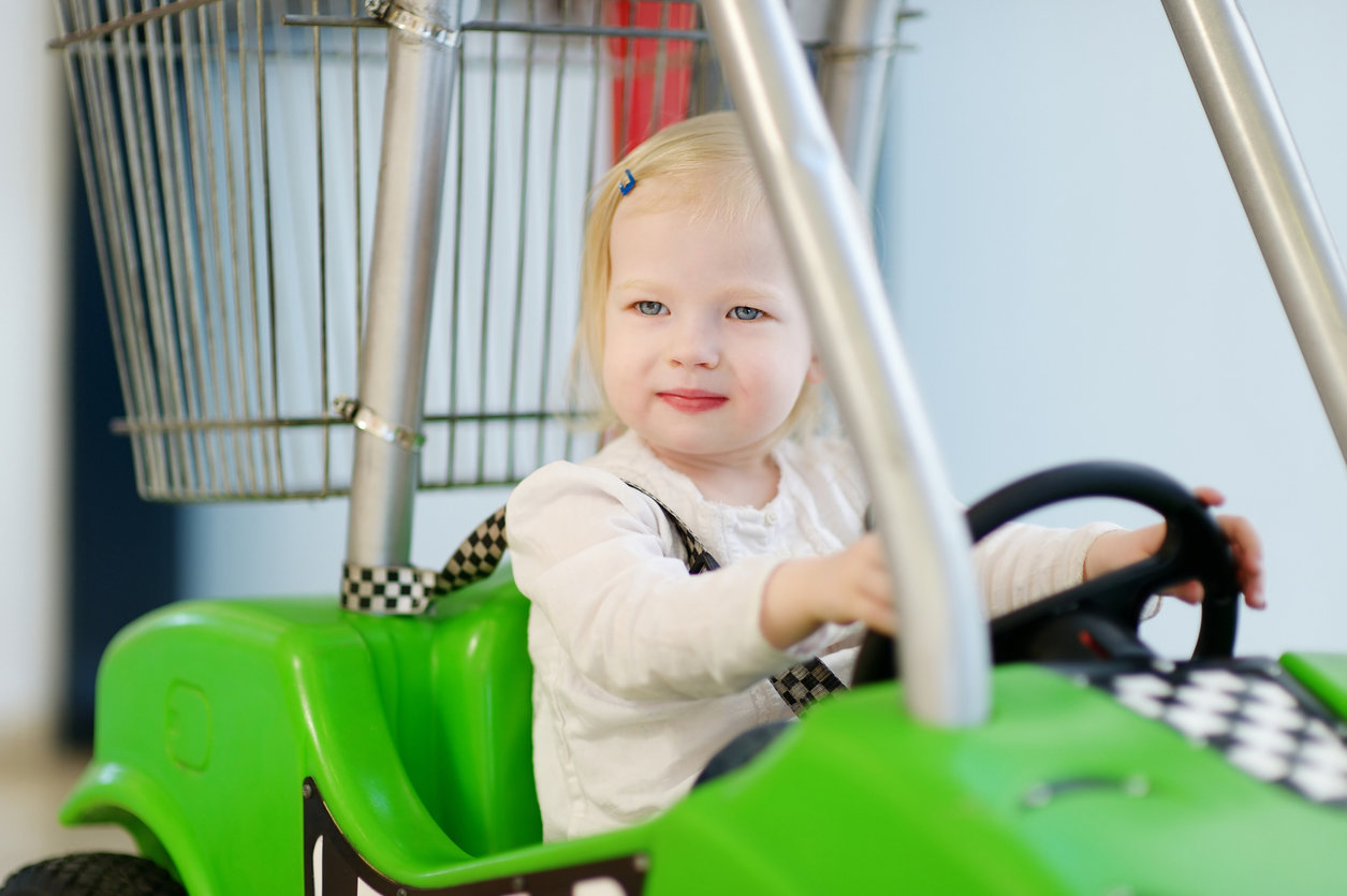 little girl in grocery store shopping cart