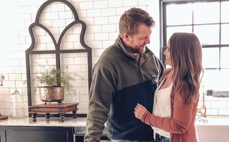 Holly Simon stares lovingly into her husband's eyes while they stand in the kitchen.