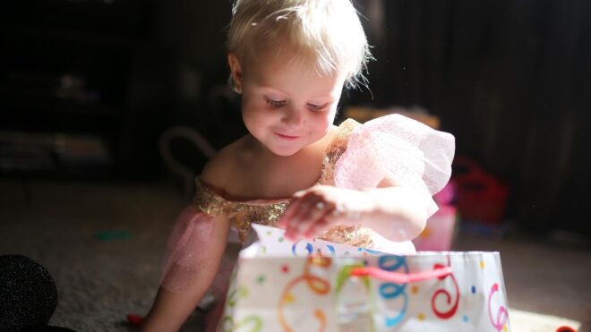 Happy Two Year Old Baby Girl Opening Birthday Presents stock photo