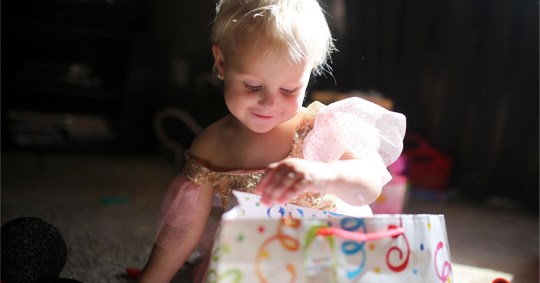 Happy Two Year Old Baby Girl Opening Birthday Presents stock photo