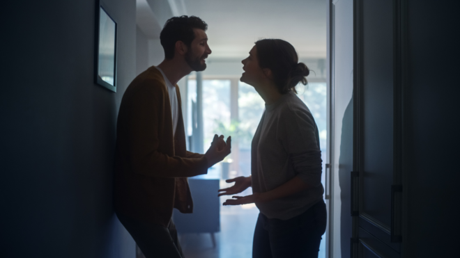 young couple slightly shadowed during an argument in a hallway
