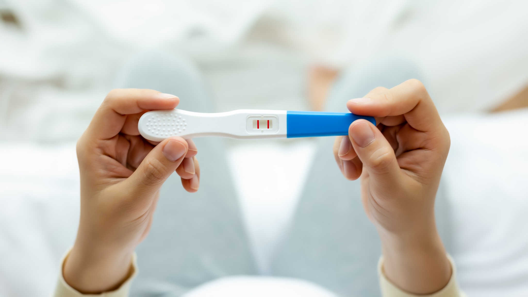 Woman holds positive pregnancy test