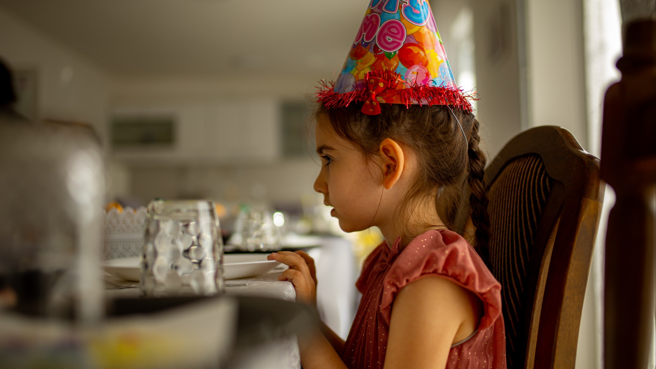 Girl with a birthday party hat on
