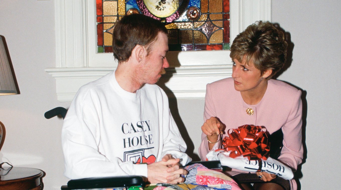 Diana, Princess of Wales sits with one of the residents of C