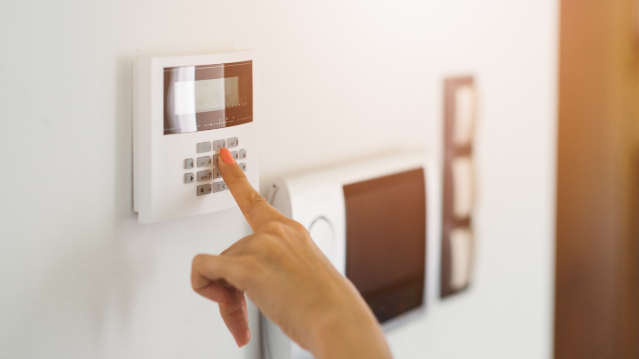 Woman enters alarm code in a house