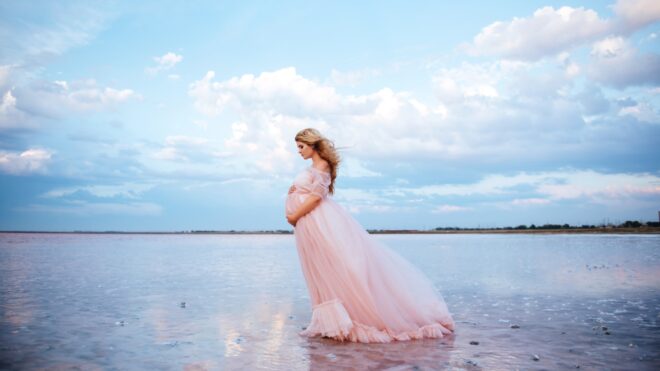 Pregnant woman poses for maternity photo on the beach