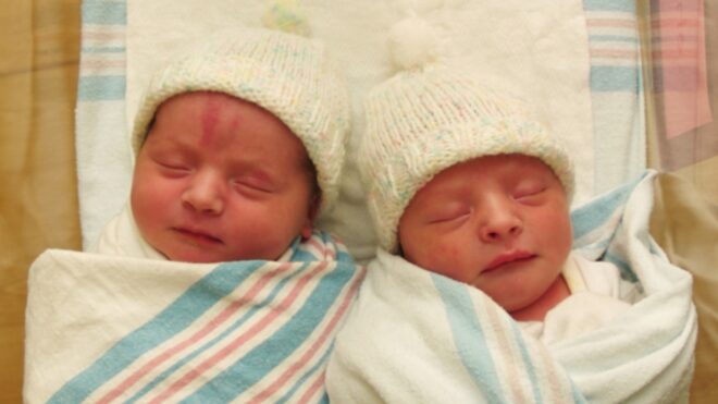 Twin babies lay side by side