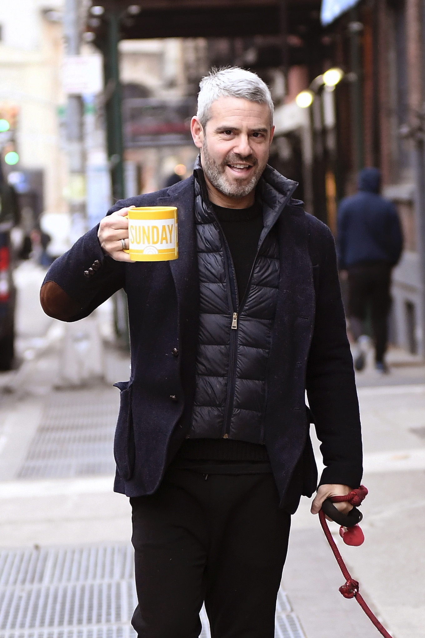 Andy Cohen Has His Hands Full While Drinking His Coffee And Walking His Dog Watcha In New York City This Morning