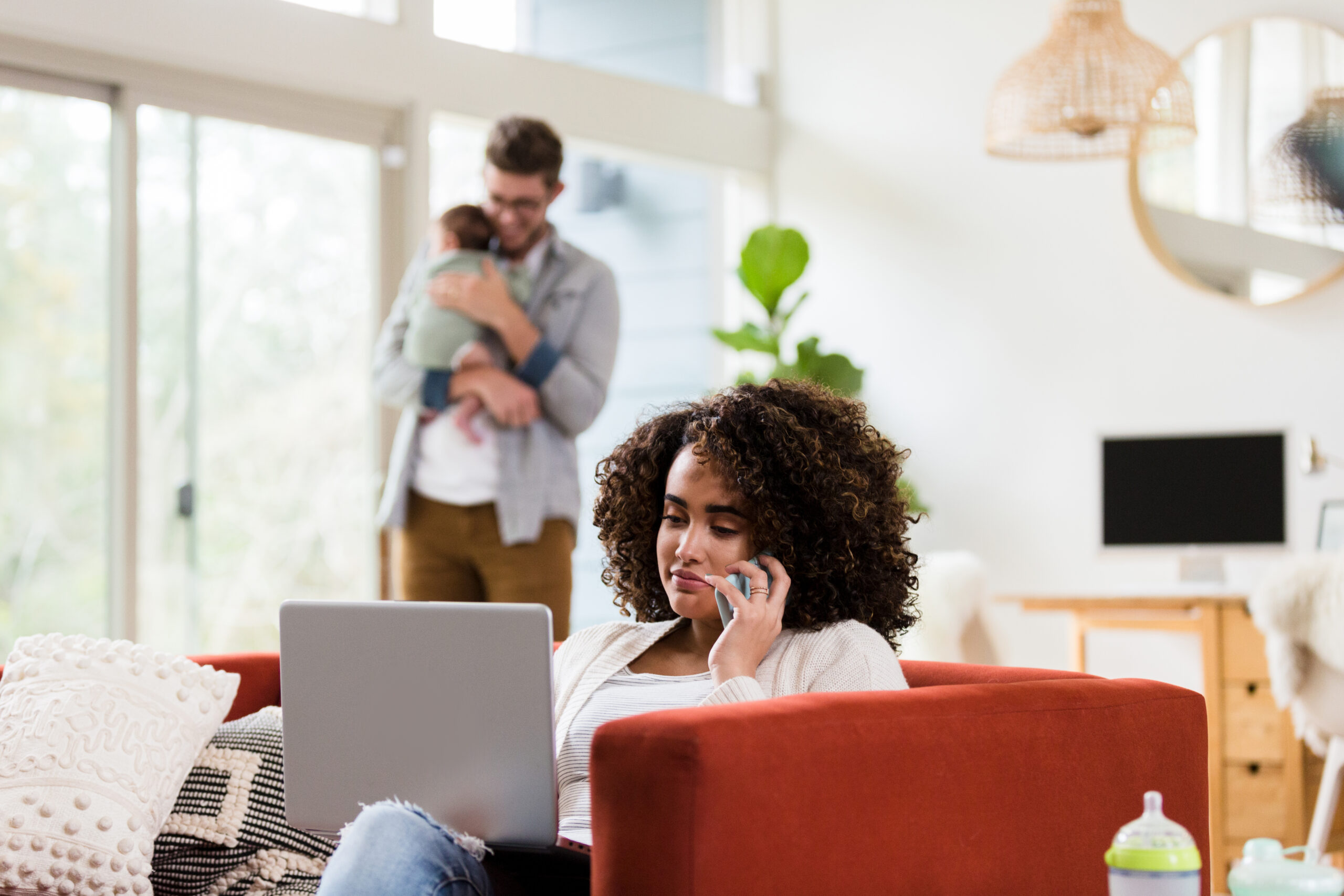 Working mom uses laptop as husband cares for baby Working mom uses laptop as husband cares for baby