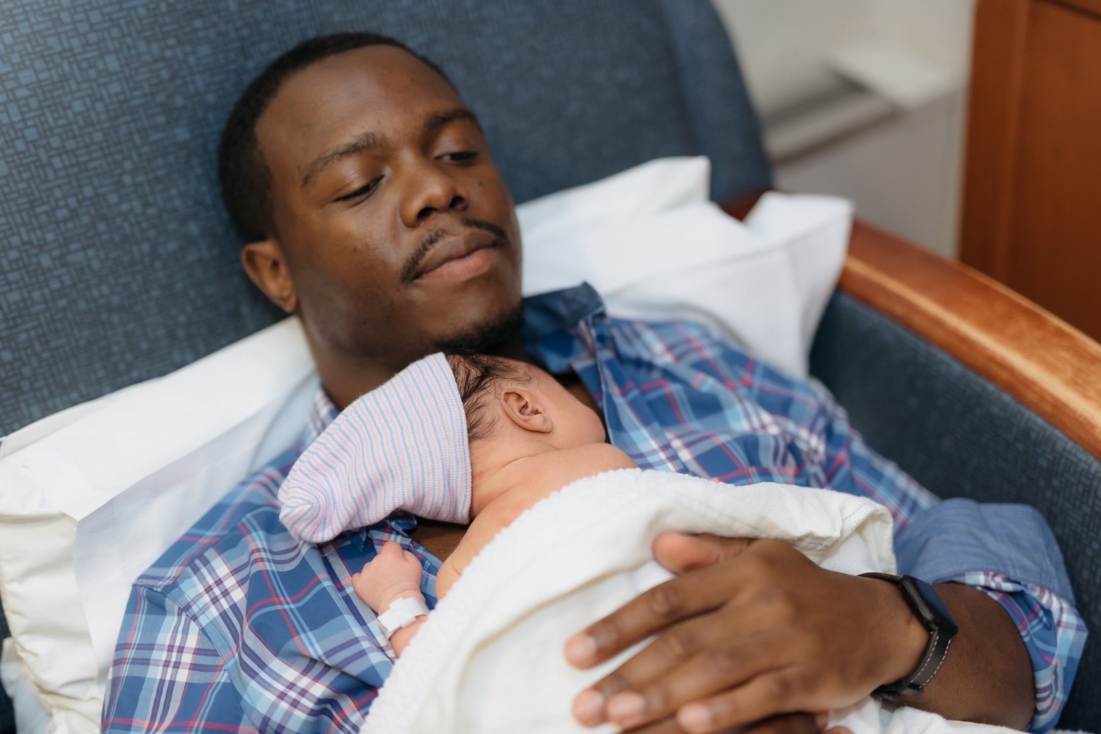 african-american-father-with-newborn-son-on-his-chest-laying-in-hospital-chair_t20_OzrJBO.jpg