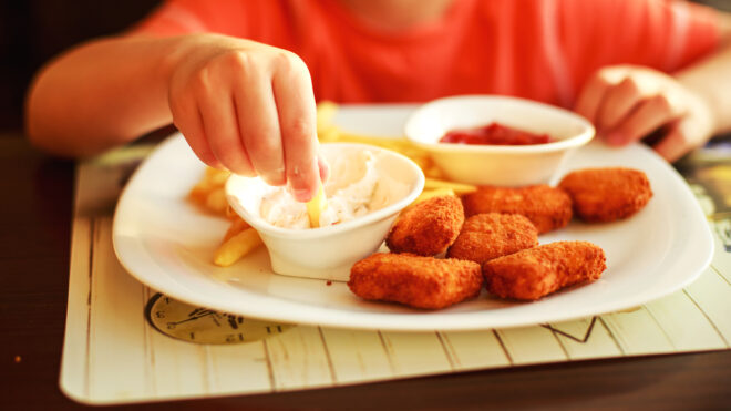 child eating chicken nuggets