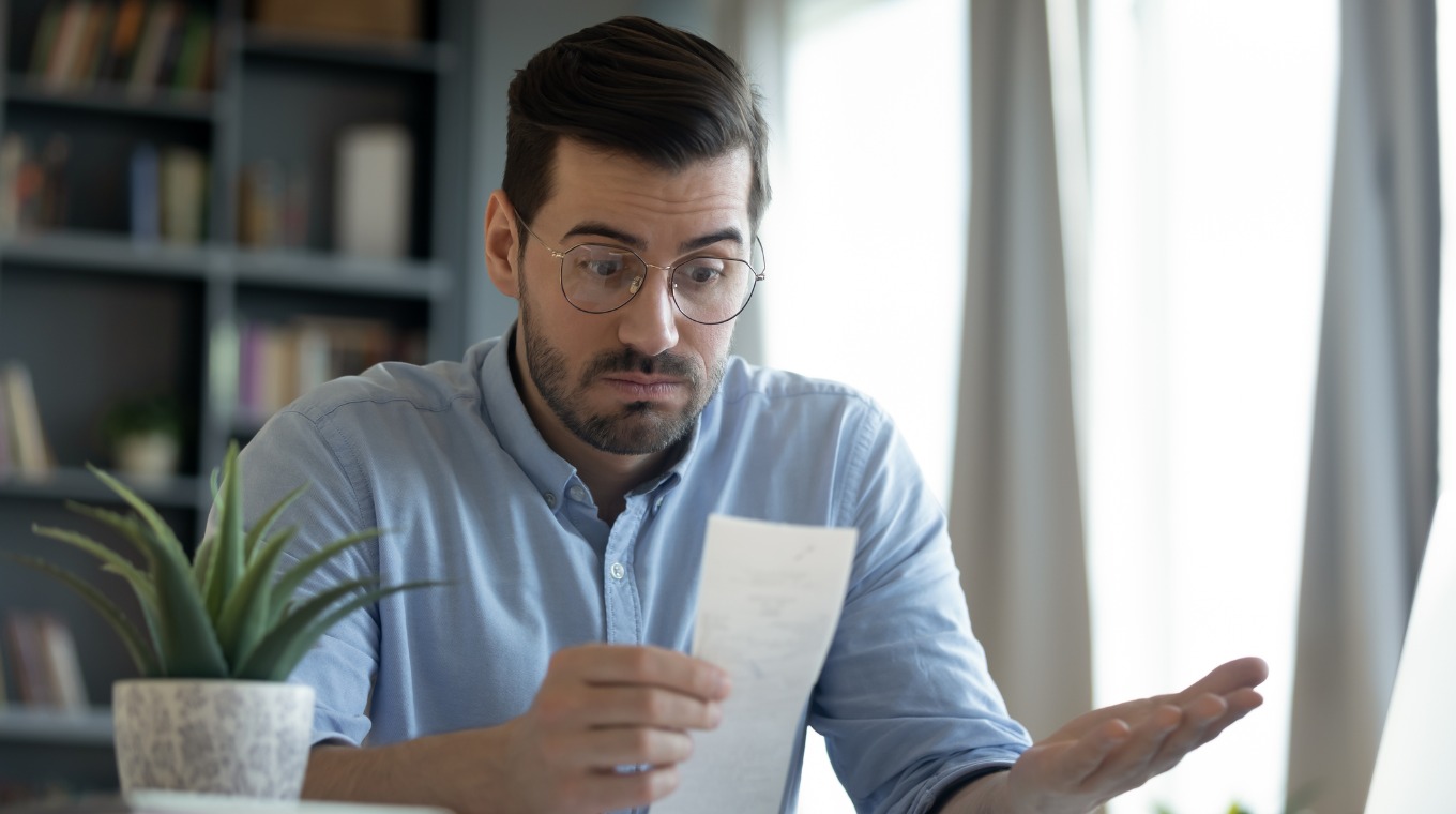 confused-shocked-man-looking-at-receipt-checking-bills-picture-id1223044345-1.jpg