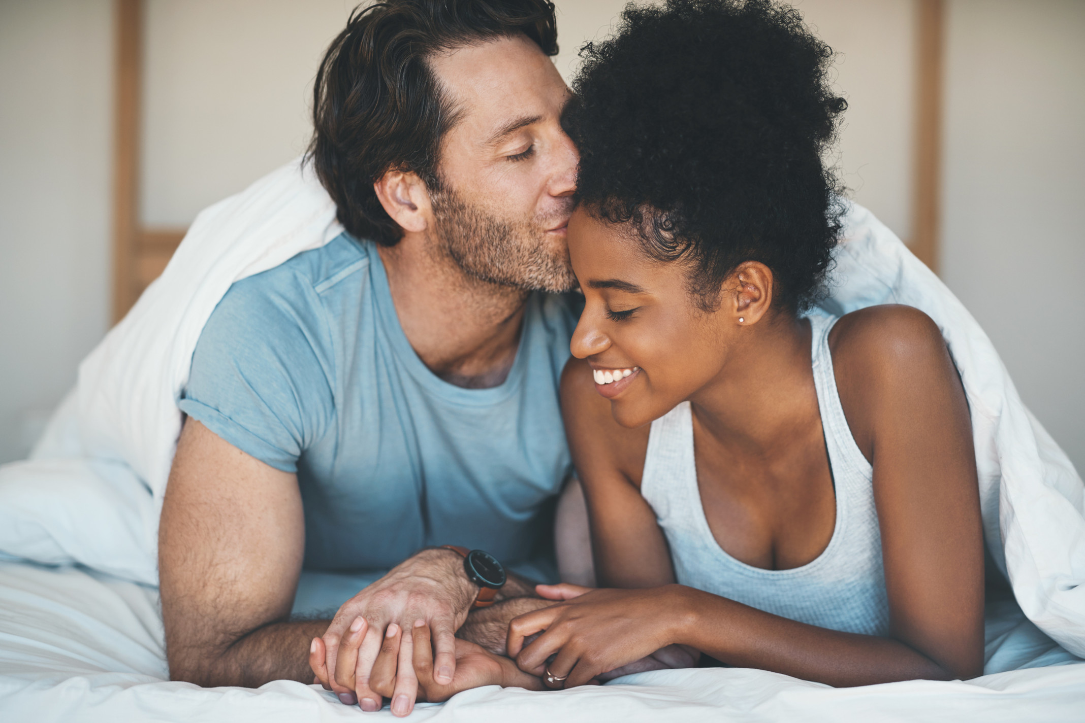 couple_holding_hands_in_bed.jpg