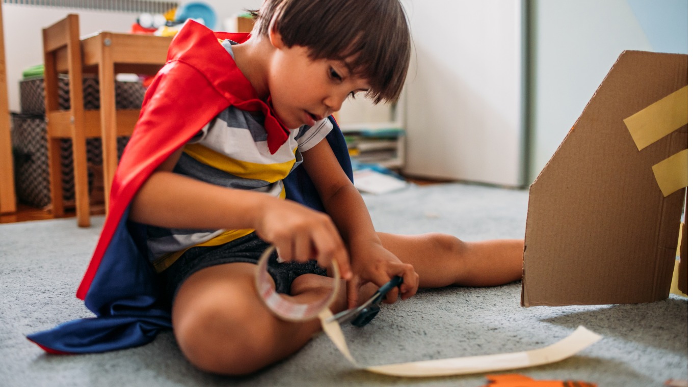 cute-little-boy-dressed-like-a-superhero-playing-with-cardboard-at-picture-id1165716095.jpg