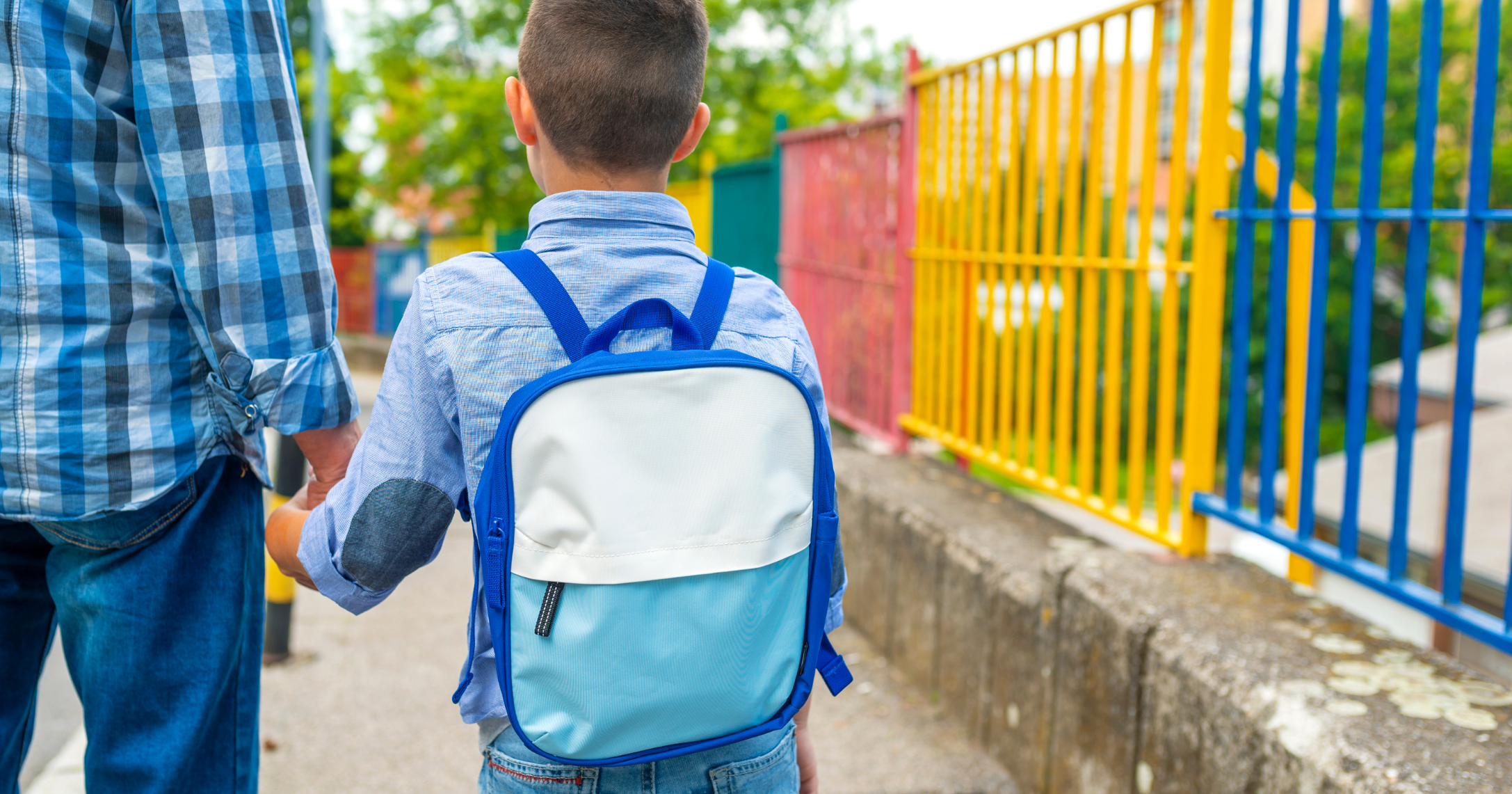 Child with a backpack holding dad's hand