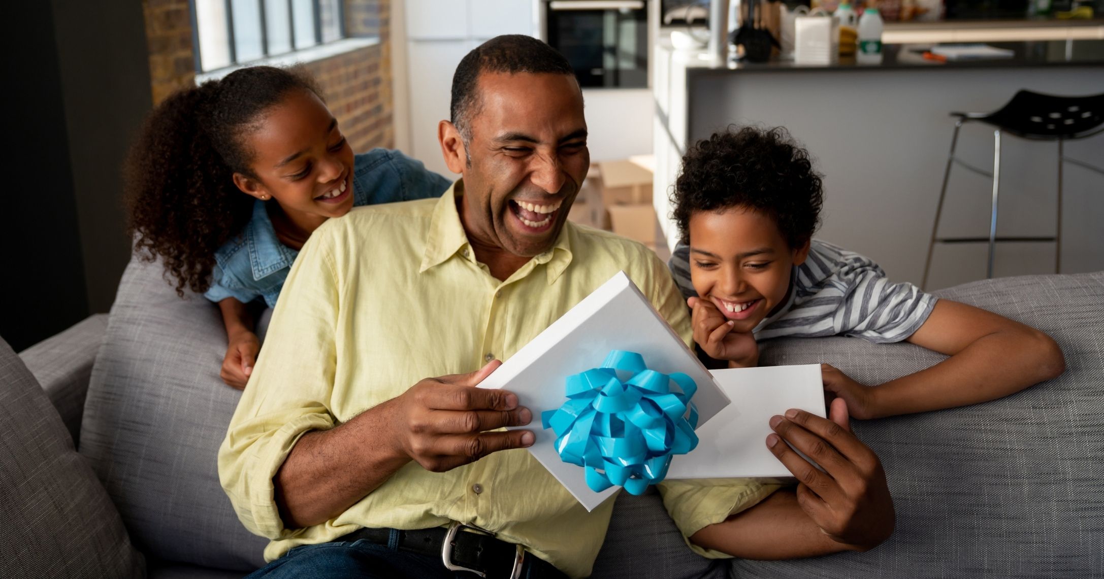 father receiving gift from two kids