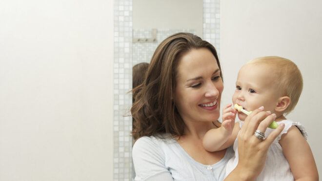 mom brushing baby's teeth