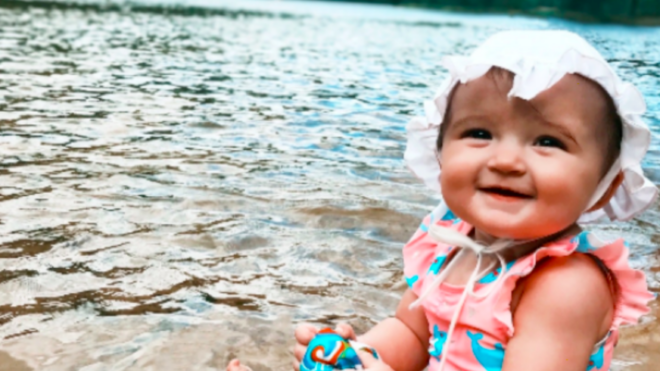 Little baby girl resting on the beach