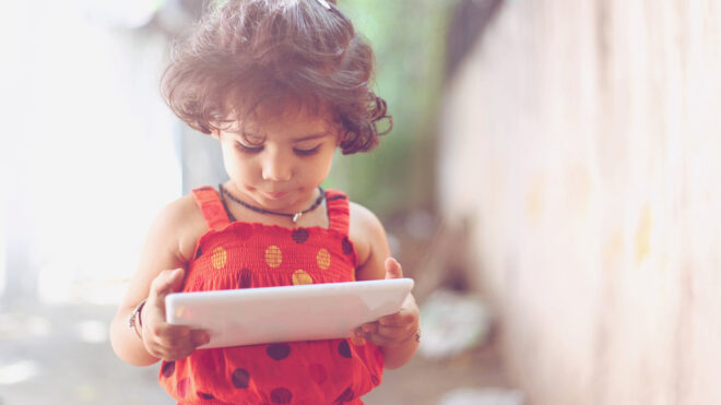 Close-up of a cute little girl using a digital tablet