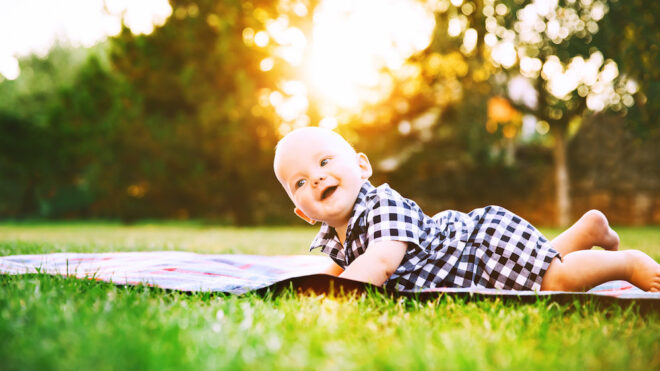 baby lying in green grass