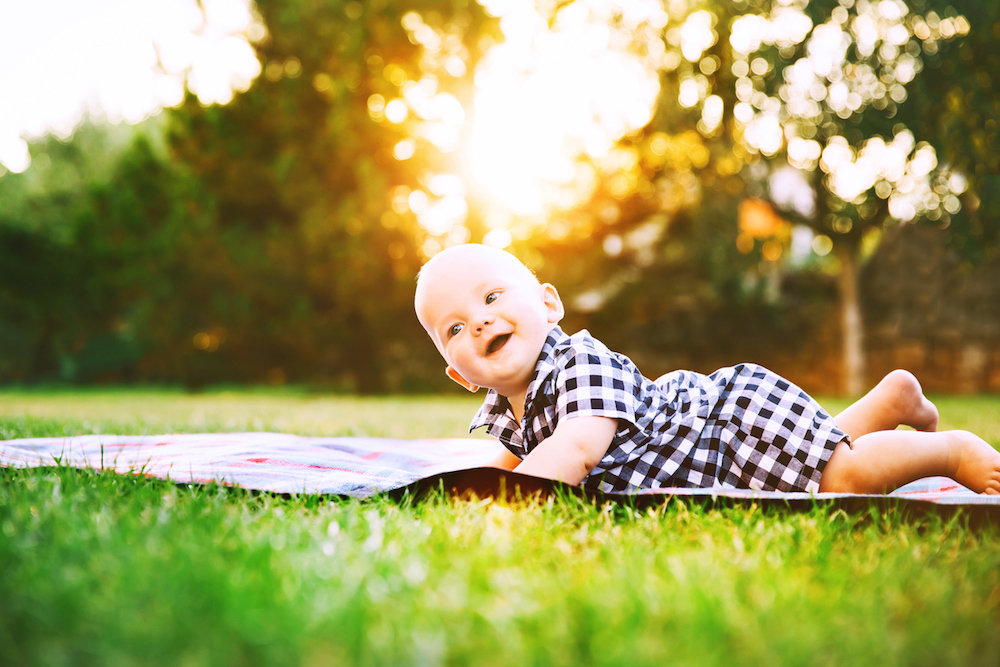 baby lying in green grass