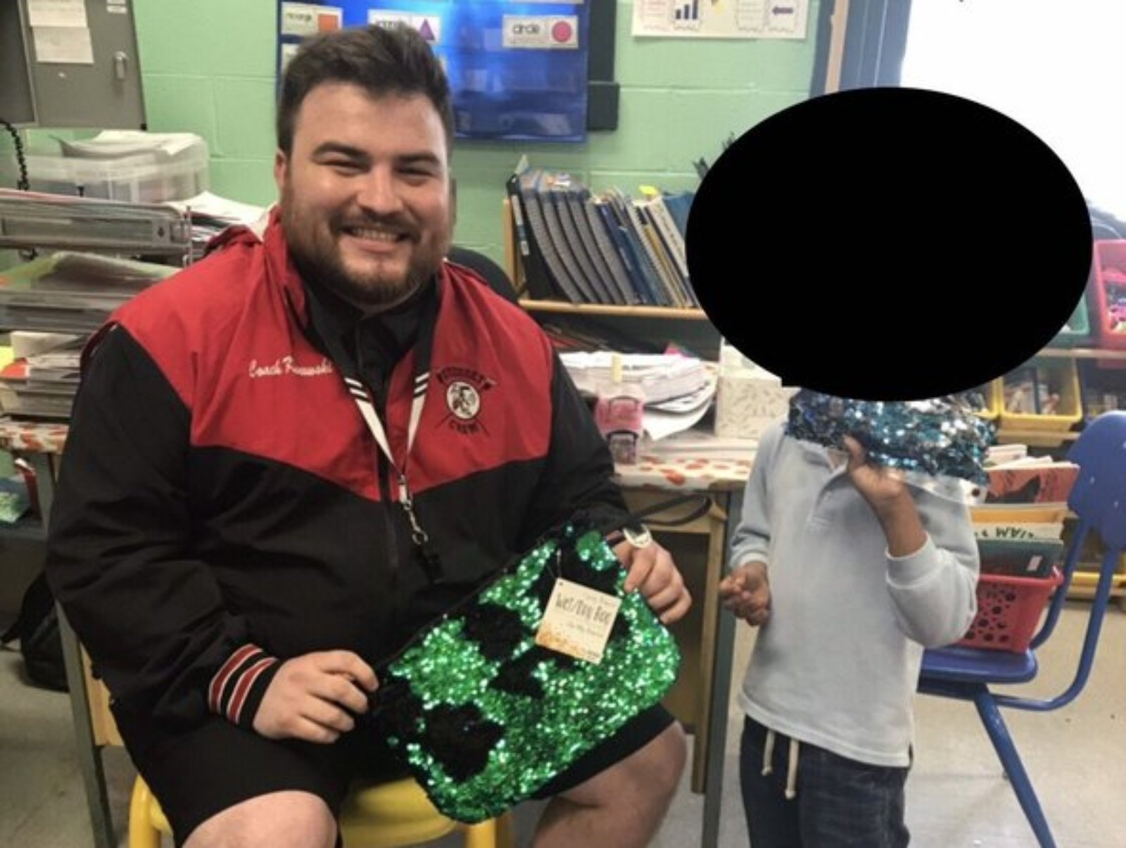 Joe Klanowski sits in a classroom showing off his sequin bag next to the boy who was teased.