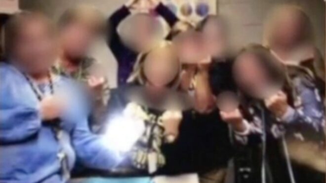 A photo of Taylor HS teachers giving the middle finger to camera. Teachers' faces are blurred out.
