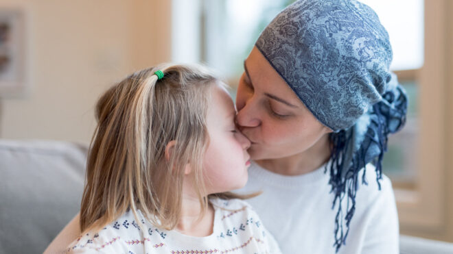 Mom with cancer kissing daughter