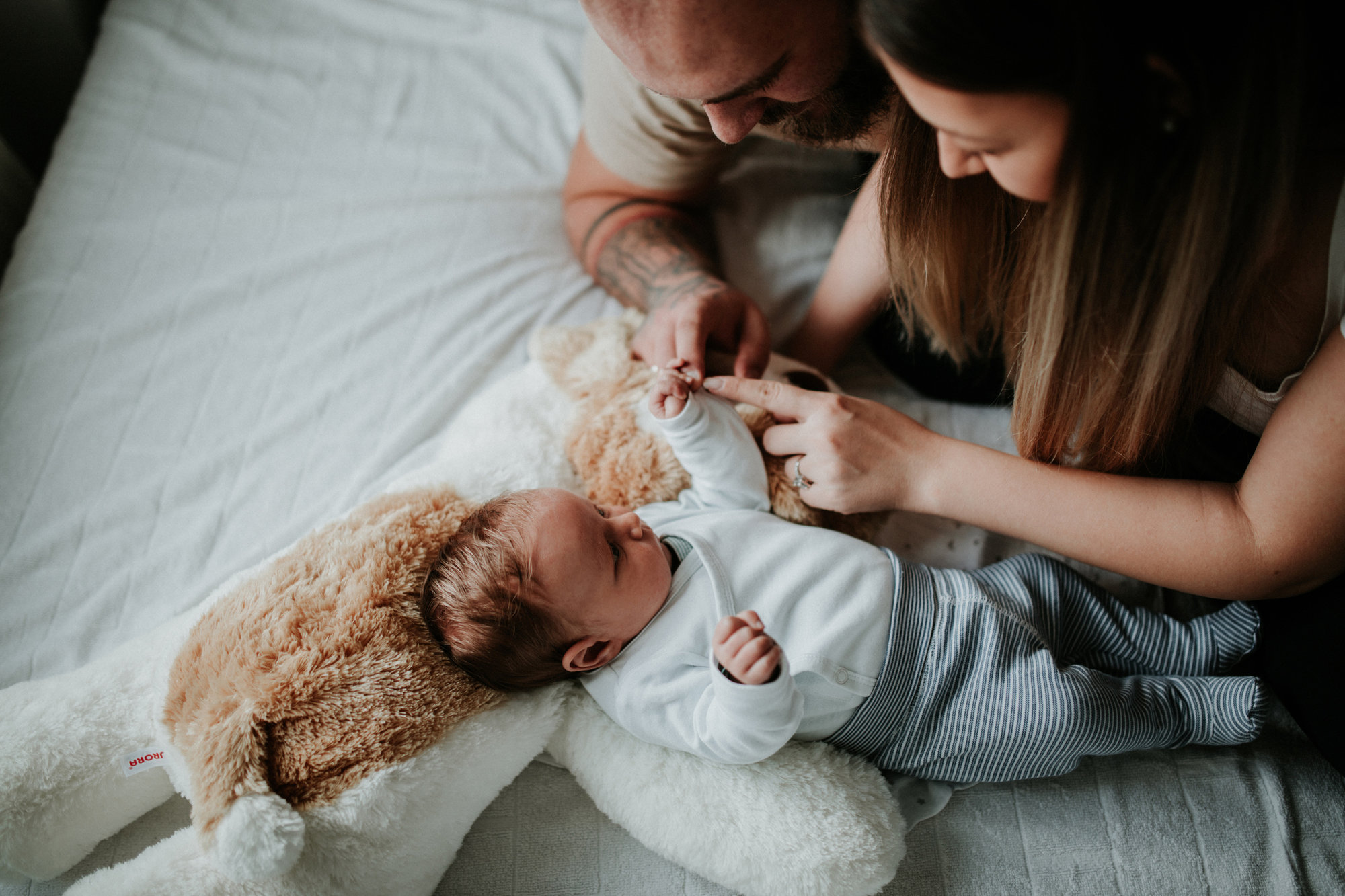 Two parents stand over their newborn
