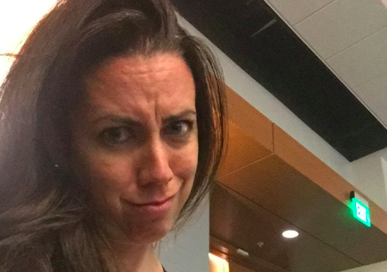 Michelle Solone makes an unhappy face while breastfeeding her daughter in a lecture hall.