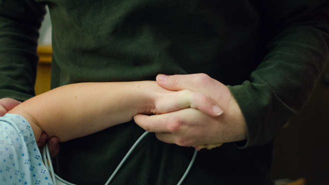 dad holding mom's hand during birth