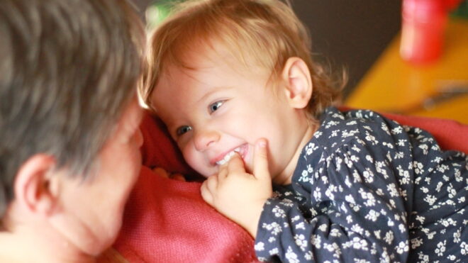 A grandmother holds a toddler girl close.
