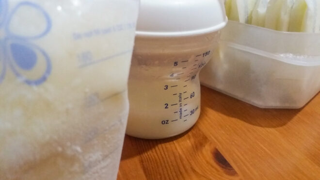 Close-up on a bottle and a storage bag of breast milk.