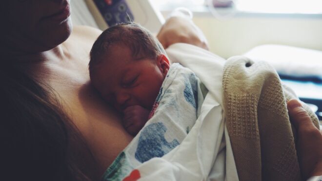 A mom holds her newborn close at the hospital