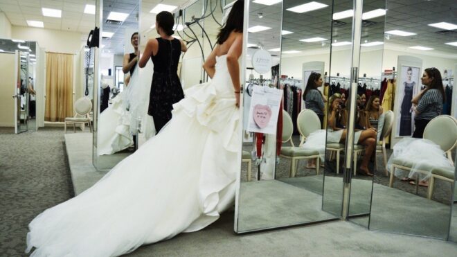 Woman tries on wedding gown at a bridal boutique.