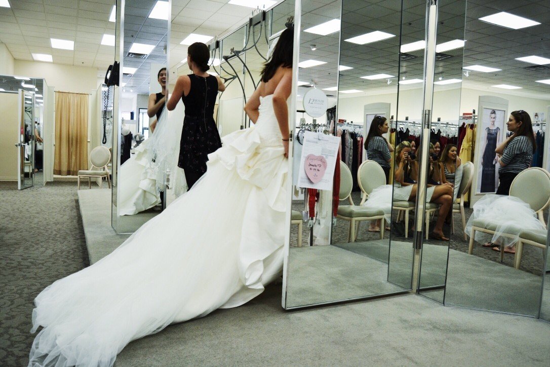 Woman tries on wedding gown at a bridal boutique.
