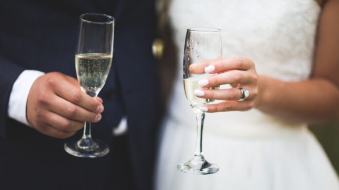 Bride and groom hold champagne for a toast