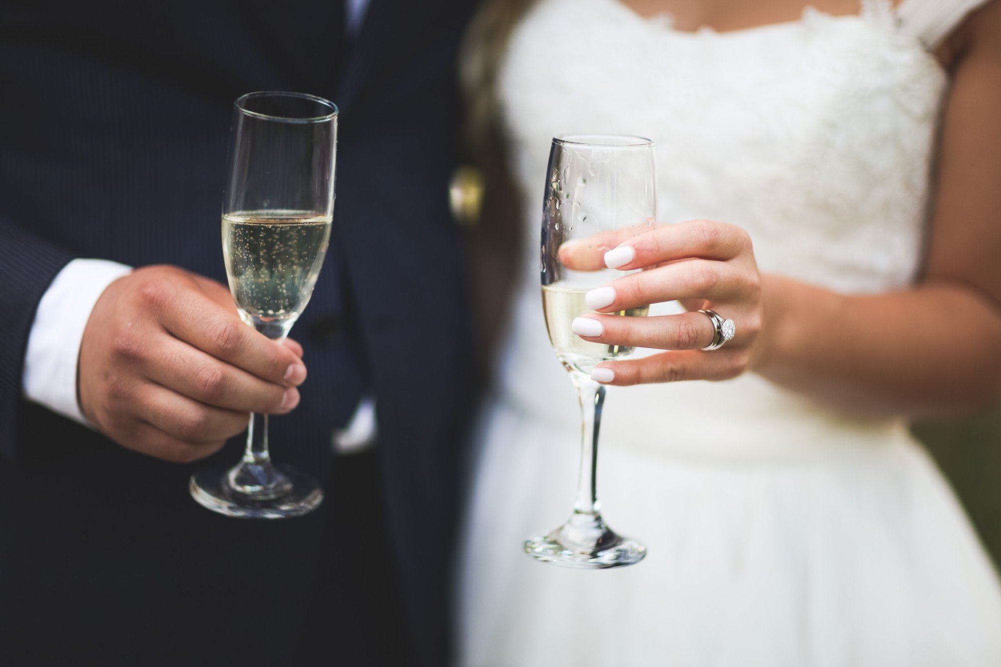 Bride and groom hold champagne for a toast