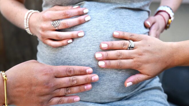 Hands touching pregnant belly